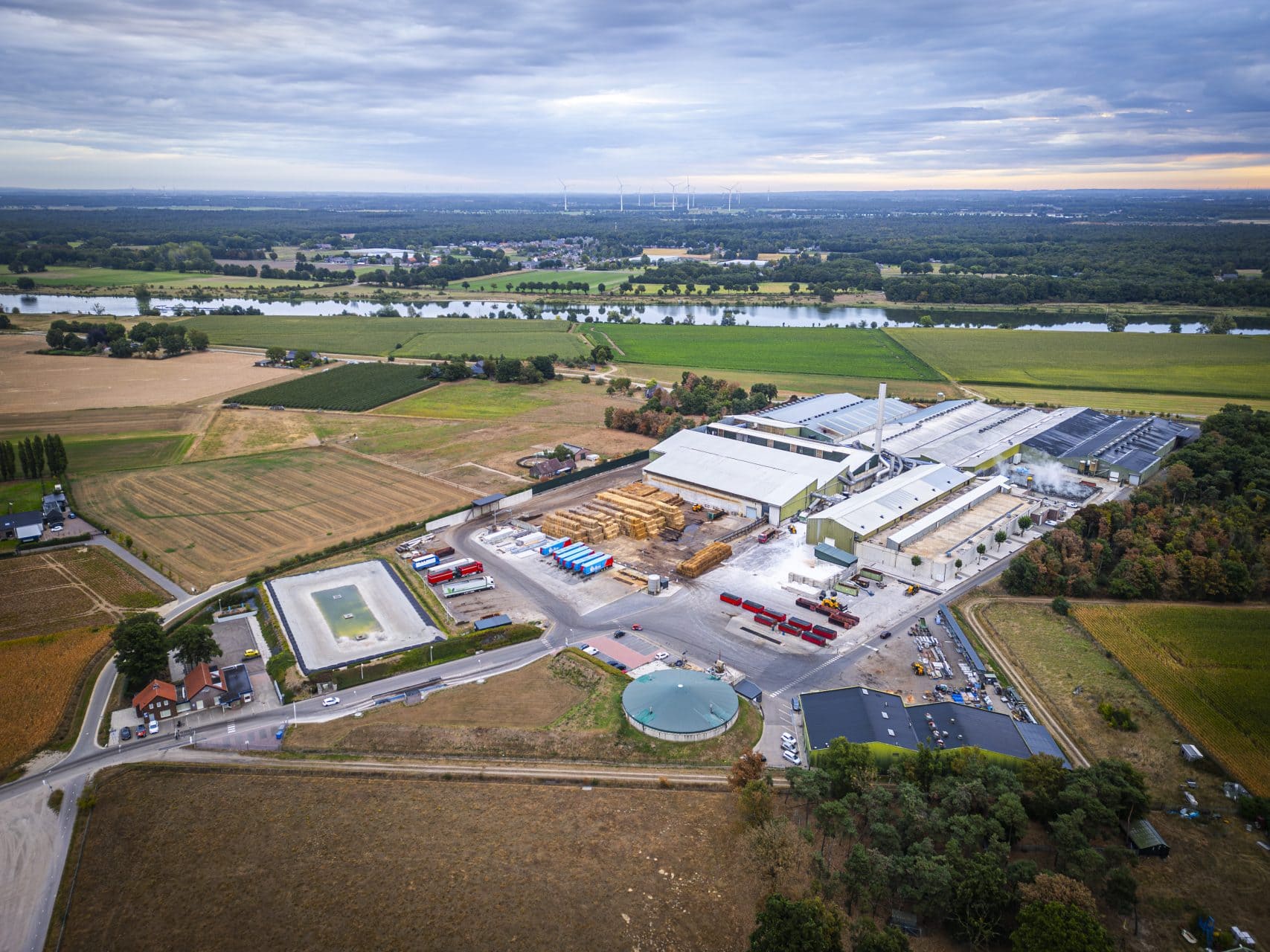 Productiebedrijf in landelijke omgeving met grote fabriek en opslaghallen.