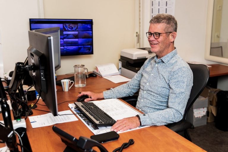 Logistiek manager Eric werkt aan zijn bureau met meerdere schermen.