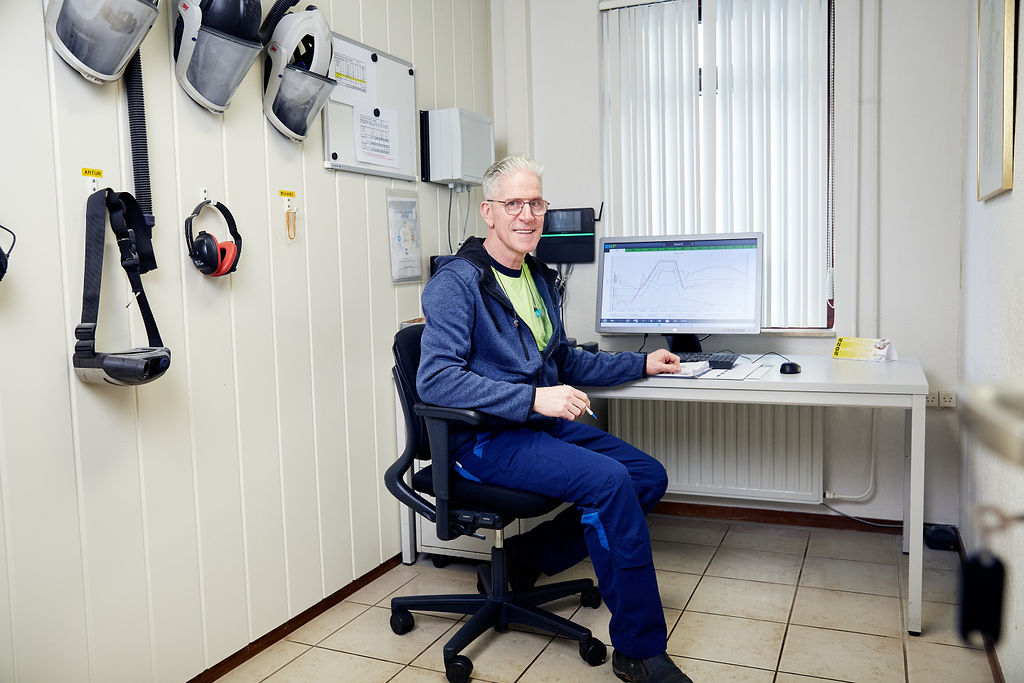Richard, productieleider, werkt in kantoor met technische apparatuur.
