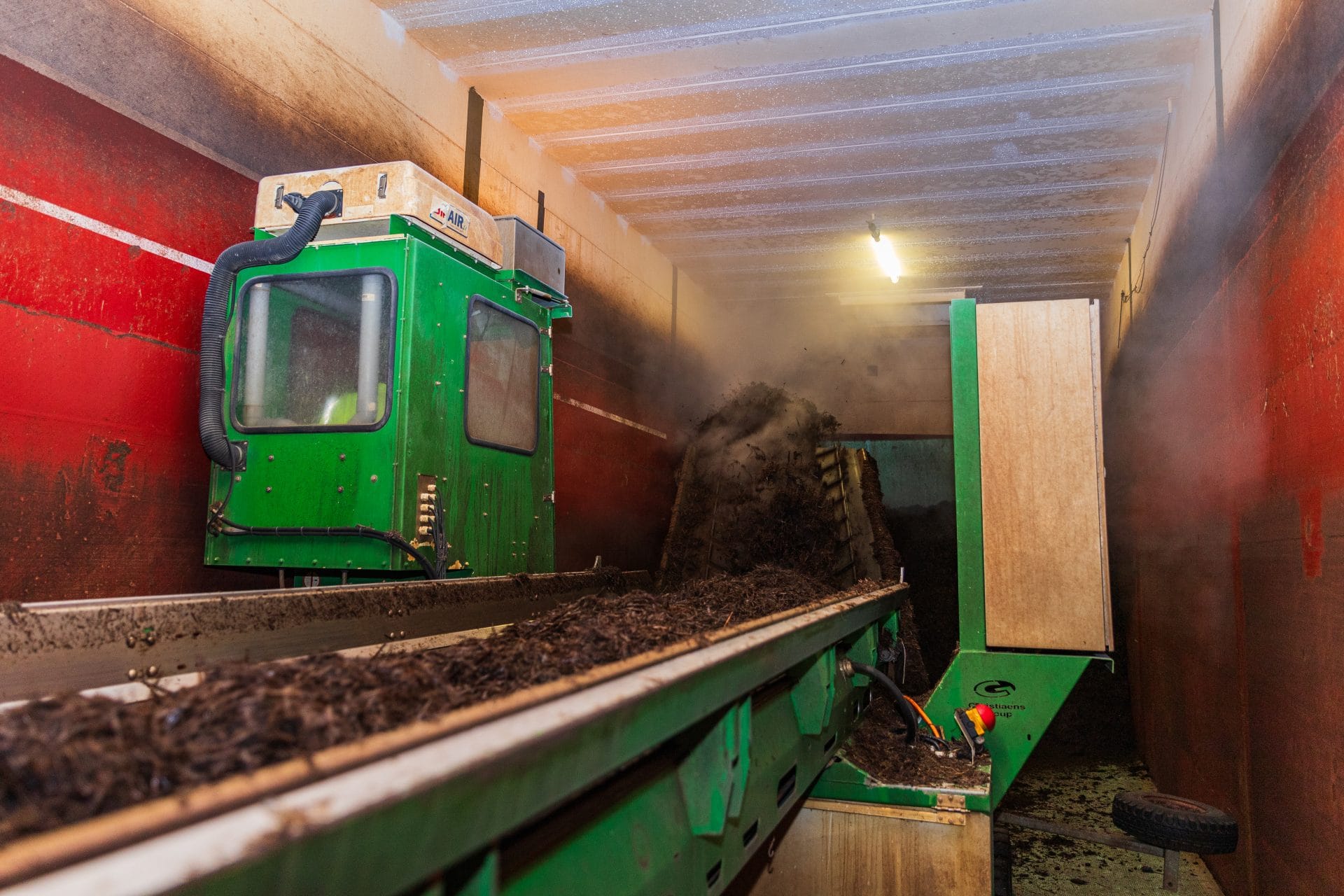 Procesinstallatie voor houtbewerking en verwerking, met een groene machine die houtafval verwerkt in.